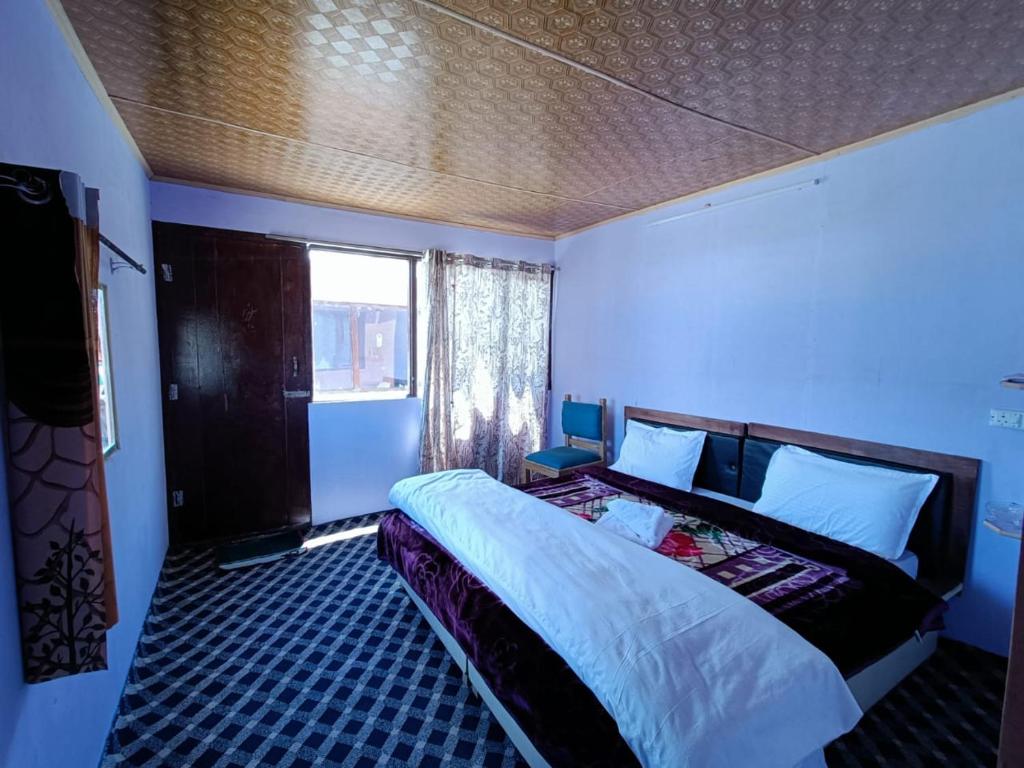 a bedroom with a large bed in a blue room at Native Retreat Cottage , Pangong ladakh UT in Meruk