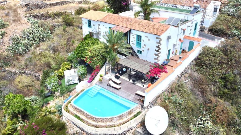 Wonderful Villa with heated infinity pool, Ocean View in Tenerife South في سان ميغيل ذي أبونا: اطلالة جوية على منزل مع مسبح