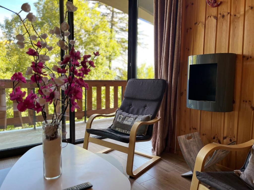 a living room with a table and a chair and a television at Appartement Pra-Loup, 3 pièces, 6 personnes - FR-1-165A-54 in Uvernet