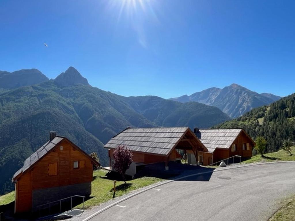 dois celeiros numa colina com montanhas ao fundo em Appartement Pra-Loup, 3 pièces, 8 personnes - FR-1-165A-45 em Uvernet