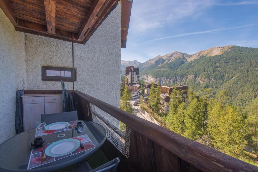 d'un balcon avec une table et une vue sur la montagne. dans l'établissement Le Sunny Snow - Jolie vue montagne, aux Orres