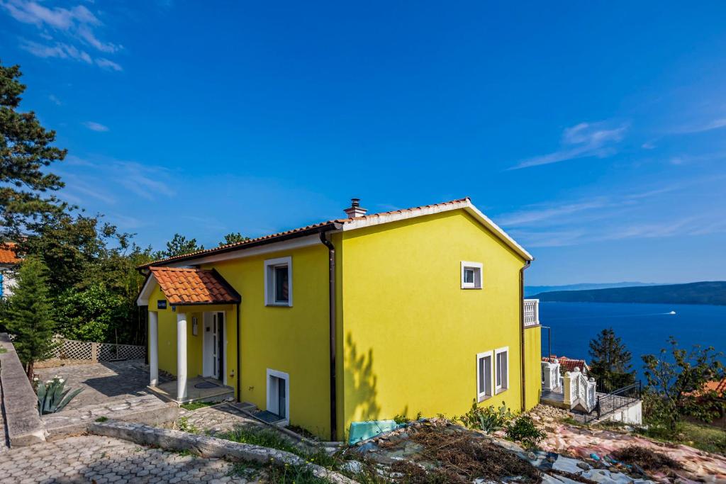 a yellow house on top of a hill at Seaview House Helena Apartments - Happy Rentals in Plomin