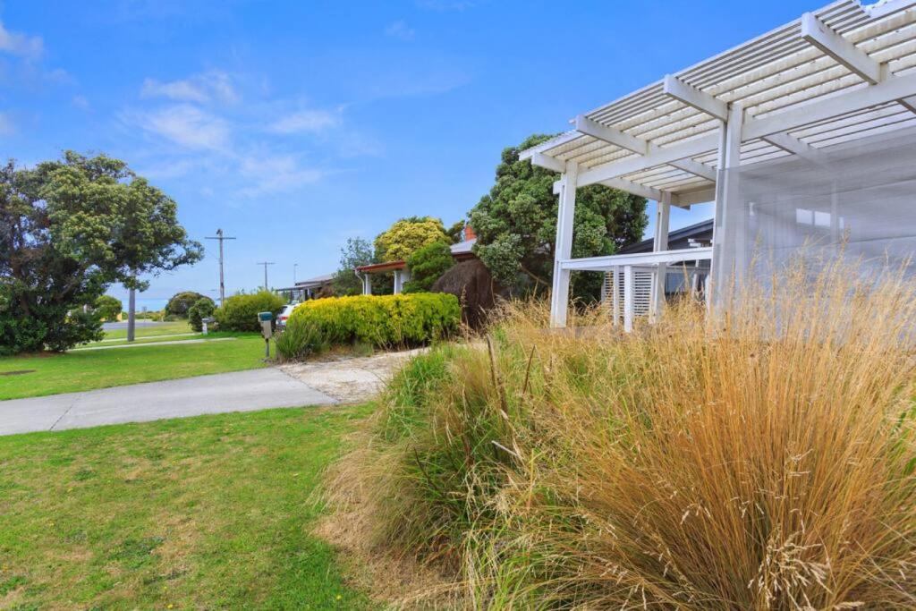 een witte pergola in een tuin met gras bij Great Ocean Road Sandy Villa in Apollo Bay
