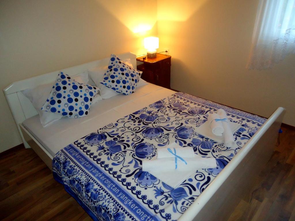 Apartment Vukanic في كوتور: سرير به شراشف ووسائد زرقاء وبيضاء