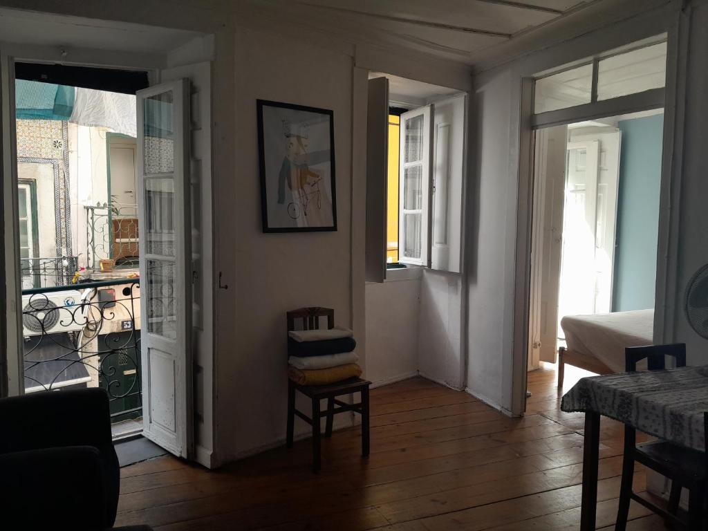 un soggiorno con sedia e una porta che conduce a un balcone di Chiado / Carmo Small Artist Lodge a Lisbona