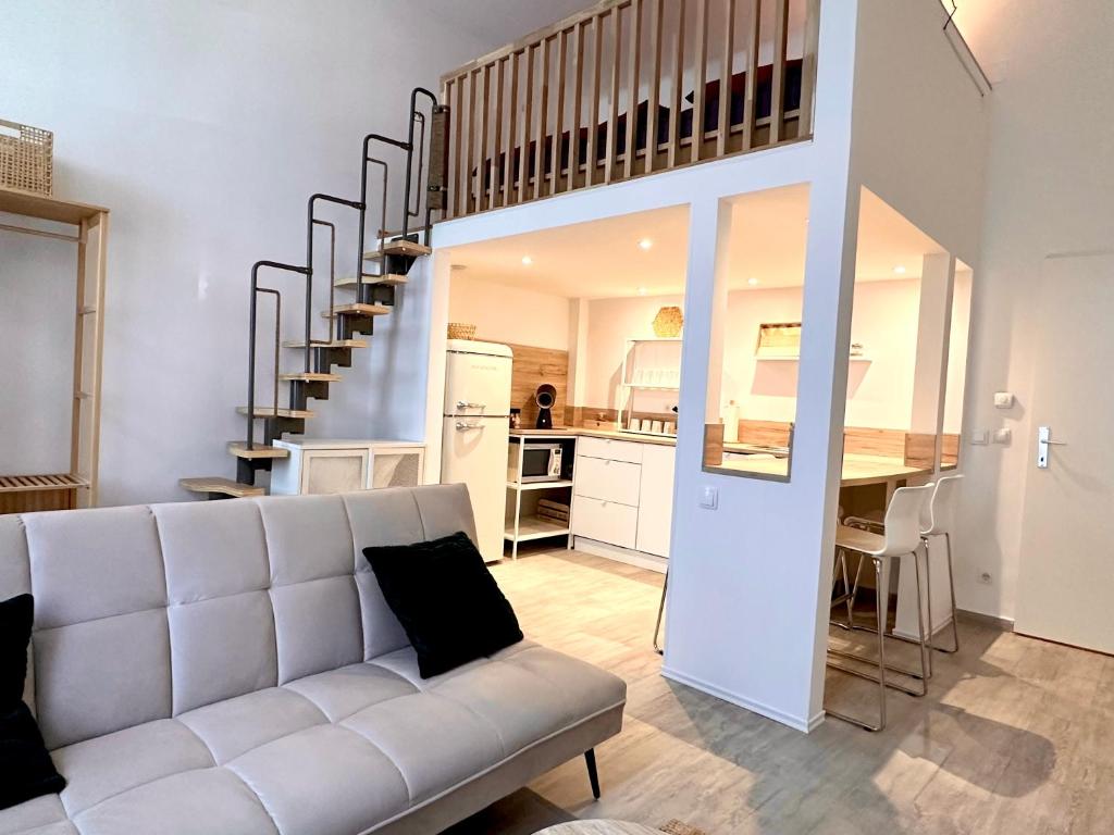 a living room with a couch and a spiral staircase at Loft Apartment am Brunnenmarkt in Vienna
