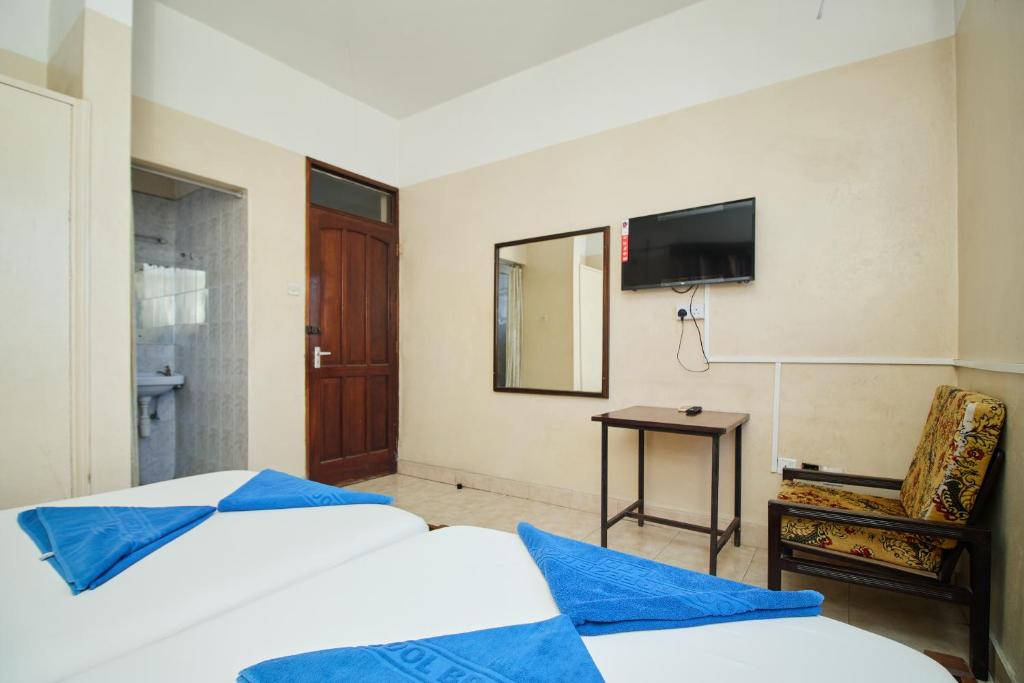 Postel nebo postele na pokoji v ubytování Mombasa Railway Gardens Hotel