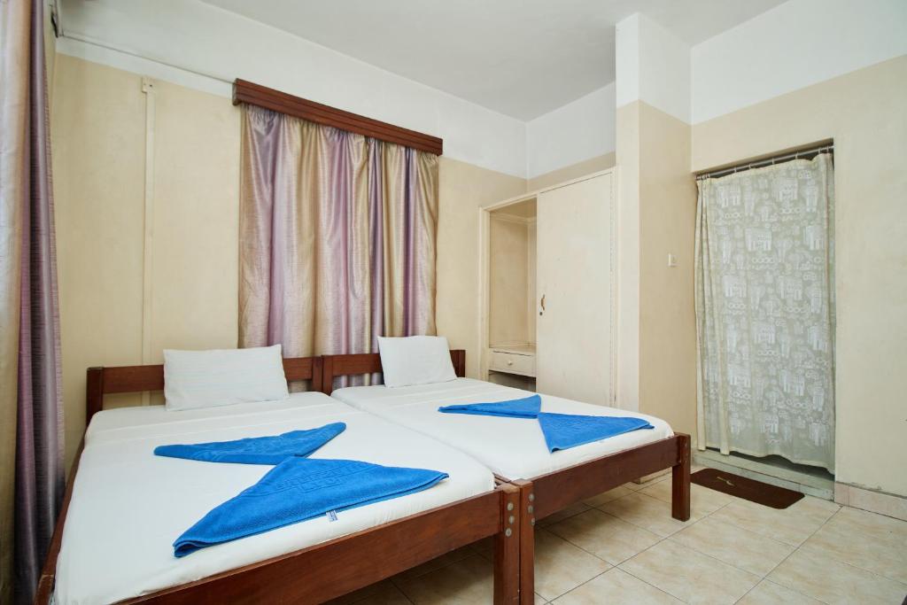 Postel nebo postele na pokoji v ubytování Mombasa Railway Gardens Hotel