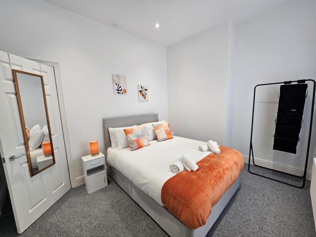 een slaapkamer met een bed met witte lakens en een spiegel bij 31 Westmorland Street by Prestige Properties SA in Barrow in Furness