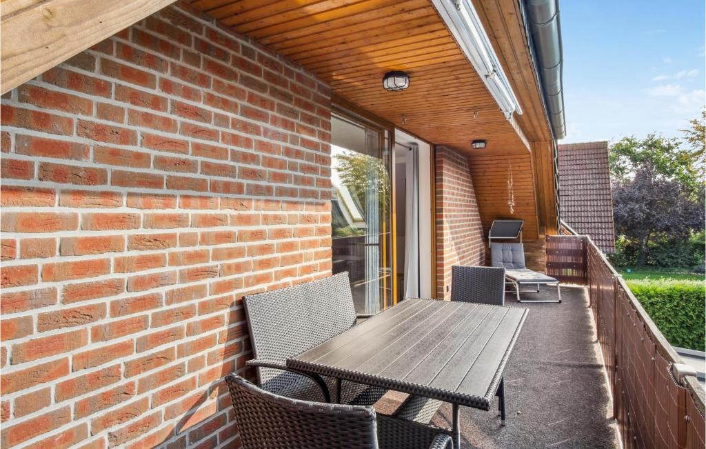 a patio with a wooden table and chairs on a brick wall at Stunning Apartment In Wendisch Evern With Wifi in Wendisch Evern