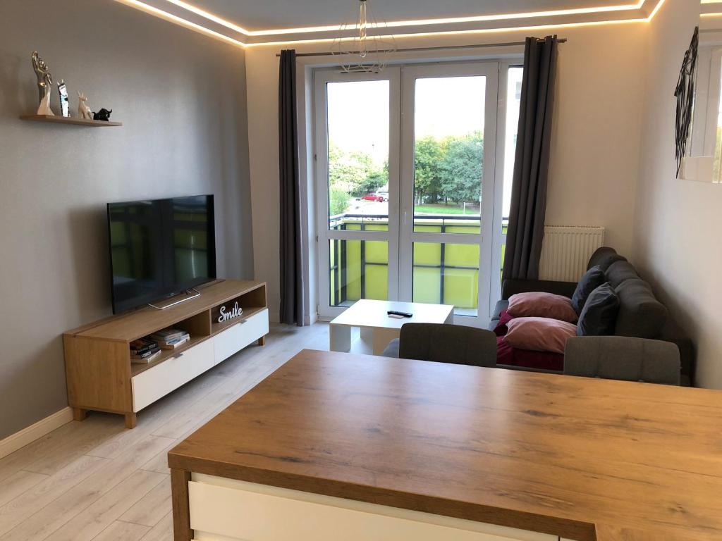 a living room with a couch and a television at Wolf Apartment in Kłodzko