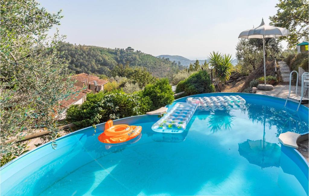 - une piscine bleue avec des chaises et un parasol dans l'établissement Awesome Home In Marliana With Outdoor Swimming Pool, à Marliana