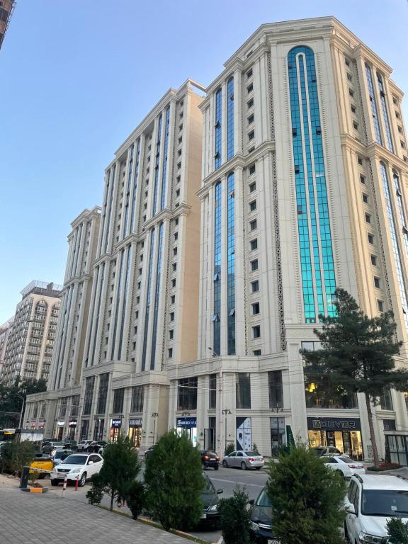 a large building with cars parked in a parking lot at Puli Sangin apartments in Dushanbe