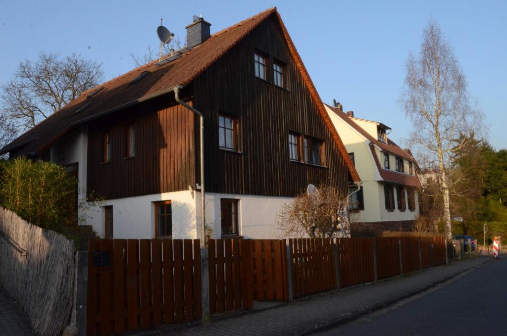 ein schwarzweißes Haus mit einem Holzzaun in der Unterkunft Apartment Albert in Erbach