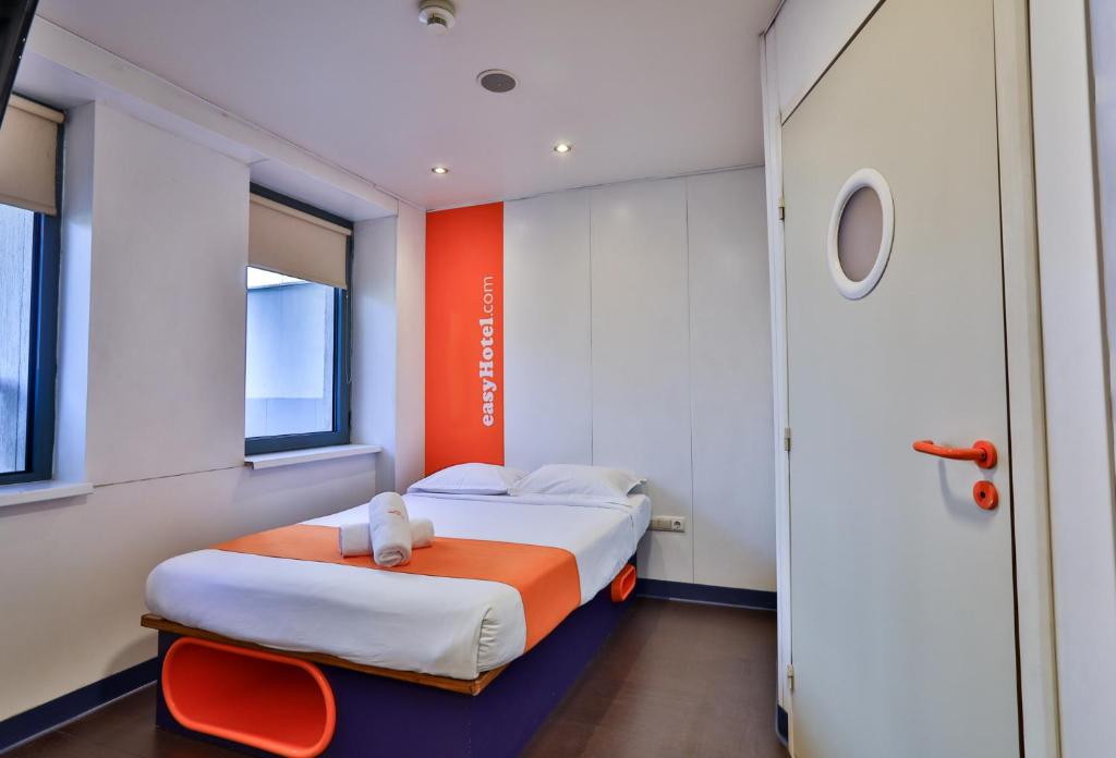una camera con un letto arancione e bianco di easyHotel Sofia a Sofia