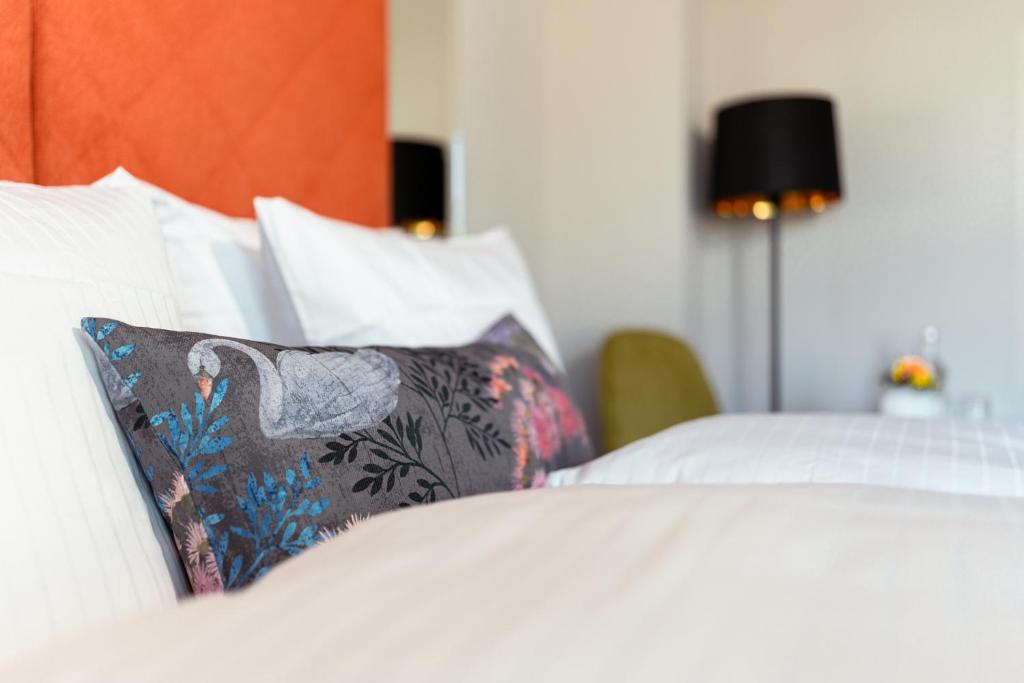- un lit avec des draps blancs et un oreiller dans l'établissement Hotel am Schwanenhaus, à Dresde