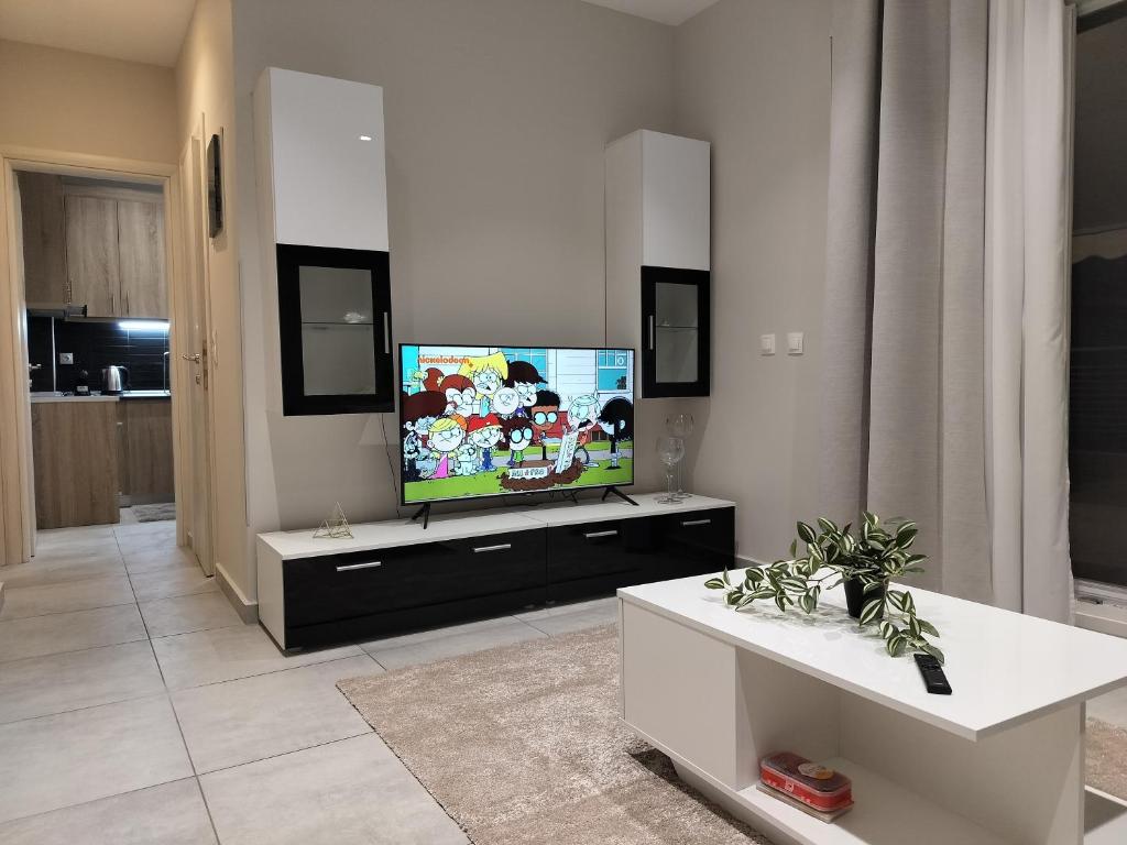 un salon avec une télévision à écran plat sur une armoire dans l'établissement PanoramicView180 1BR Welcome Stay Lux Penthouse Apartment, à Thessalonique