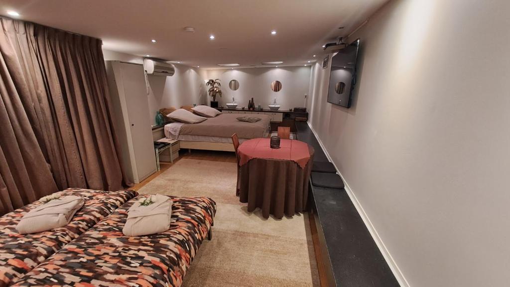 una camera d'albergo con due letti e una televisione di BeautyD Familie- of gezinskamer JUNIOR-SUITE centrum Gullegem a Wevelgem