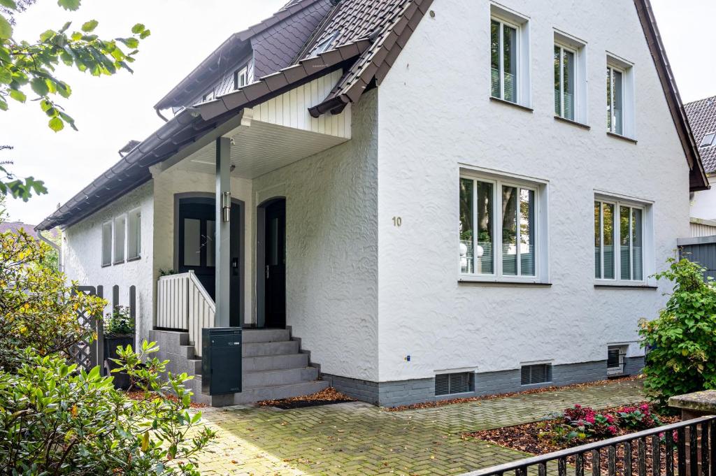a white house with a black door at Apartment Wilhelm in Nienburg