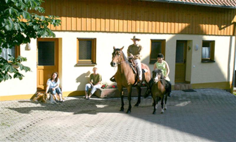 grupa ludzi jeżdżących konno przed budynkiem w obiekcie Ferienhaus Walther w mieście Erbach