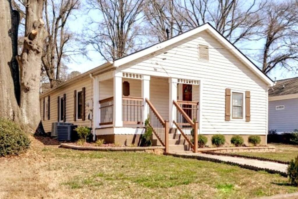 uma pequena casa branca com um alpendre em Stylish Cottage Near Airport em Atlanta