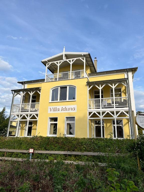 a yellow house on top of a hill at Villa Iduna mit modern desingten Apartments in Graal-Müritz
