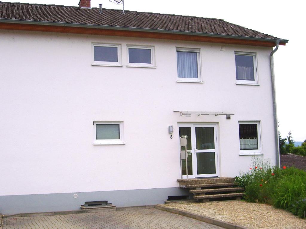 Biały dom z drzwiami i schodami w obiekcie Ferienwohnung Ottlinger w mieście Erbach