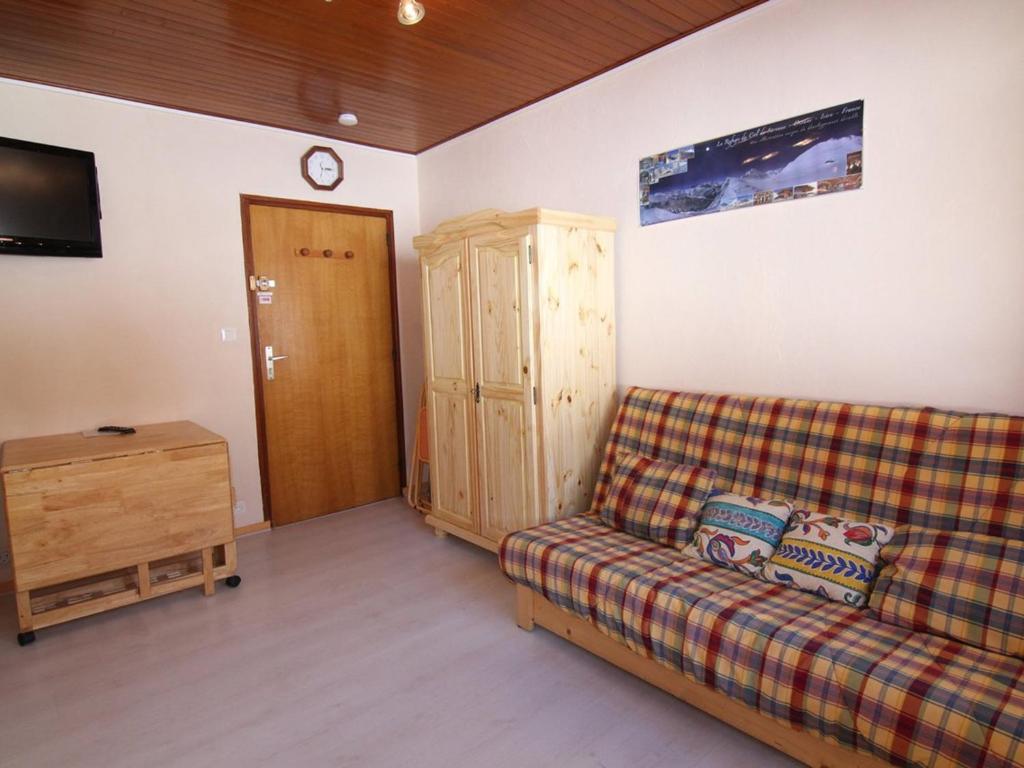 un soggiorno con divano e TV di Appartement Huez, 1 pièce, 2 personnes - FR-1-405-139 a LʼAlpe-dʼHuez