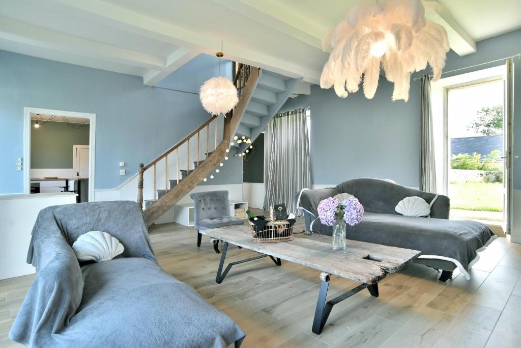 Sala de estar con 2 sofás y mesa en Ker Gheal - Jolie maison bretonne, en Plévenon