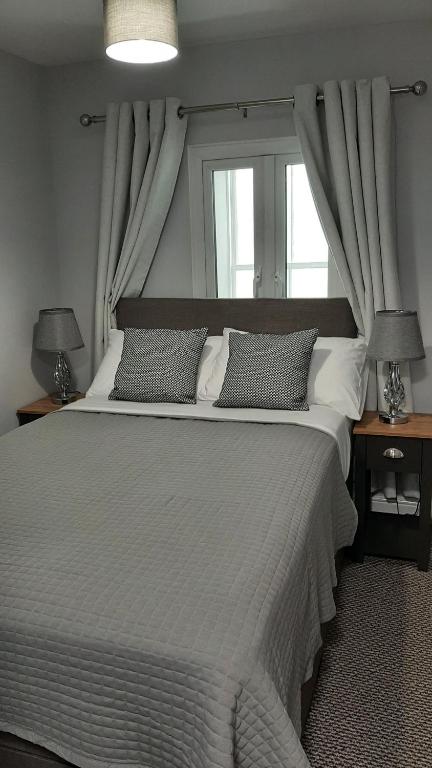 a bedroom with a large bed with a window at Poldice Valley Apartments in Chacewater