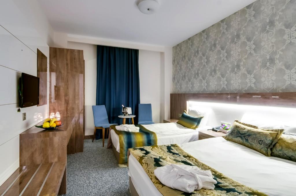 メルスィンにあるPARK YALÇIN HOTELのベッド2台とテレビが備わるホテルルームです。