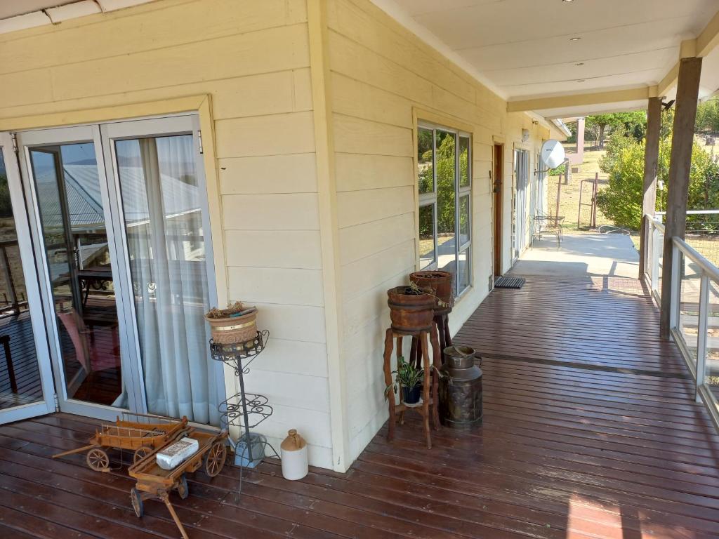 a porch of a house with a wooden deck at Twogether House in Clarens