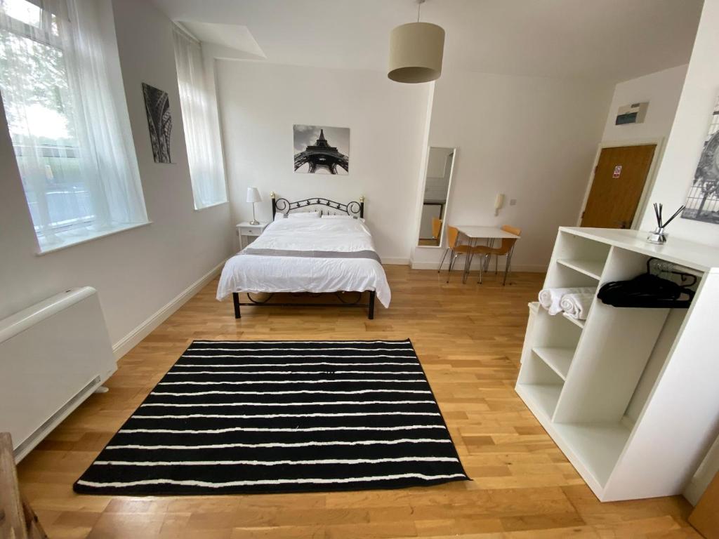1 dormitorio con cama y alfombra blanca y negra en Midland apartments- Open plan, en Leicester