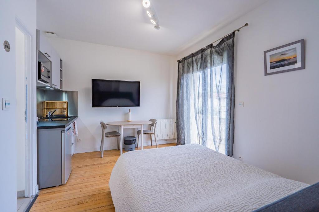 une chambre avec un lit, une table et une télévision dans l'établissement Room in Toulouse - Studio 1 proche Airbus à TOULOUSE ST Martin du Touch, à Toulouse