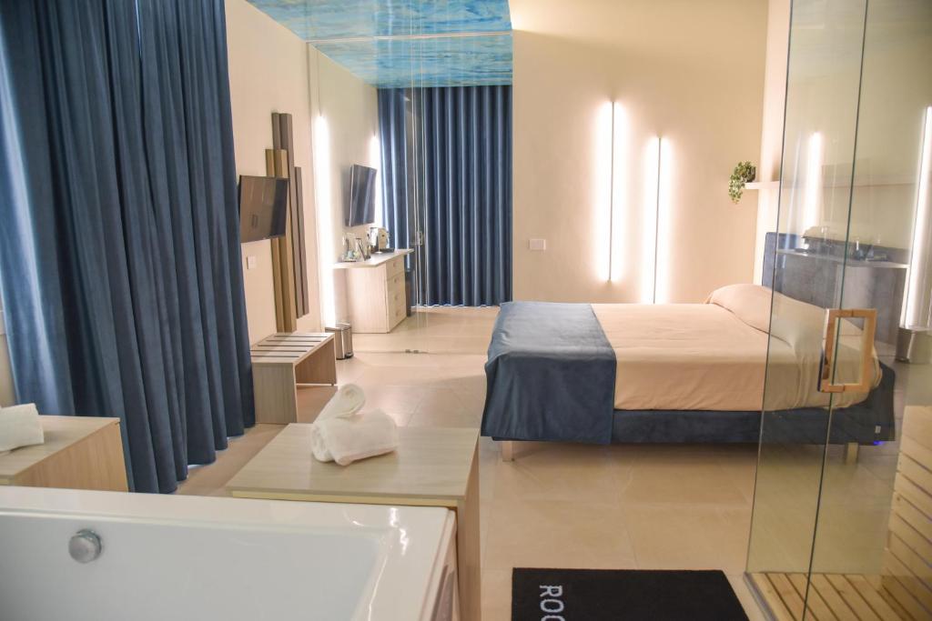 uma casa de banho com uma cama e uma banheira num quarto em Shanti Rooms & Apartments em Bacoli