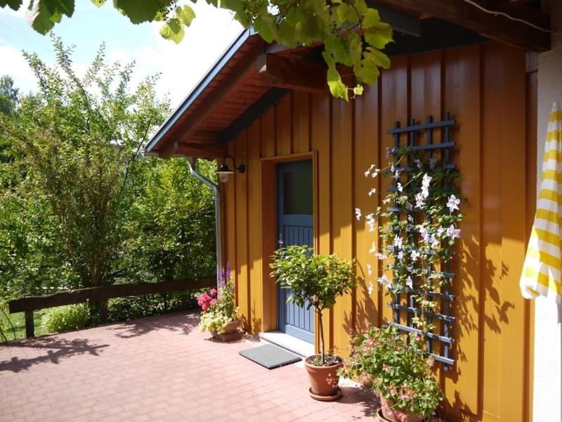 un edificio con una porta e alcune piante e fiori di Ferienwohnung Albert a Kirchzell