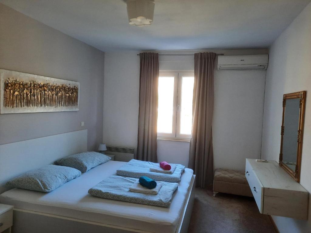 a bedroom with two beds with towels and a window at Apartman Cherine in Mostar