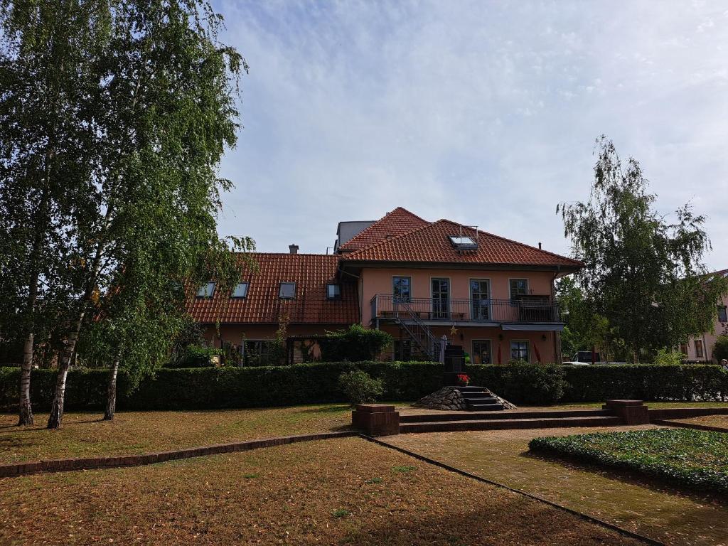 a house with a red roof and a yard at Ferienwohnung Birkenwerder bei Berlin in Birkenwerder