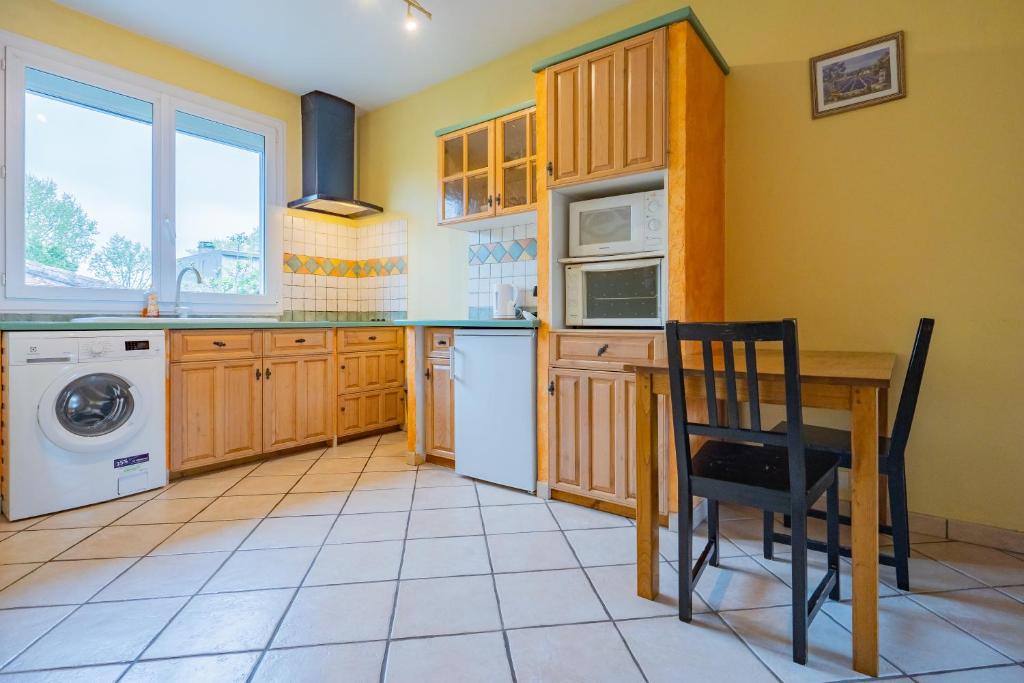 - une cuisine avec une table et un four micro-ondes dans l'établissement Room in Toulouse - Studio proche Airbus Toulouse St Martin Touch, à Toulouse