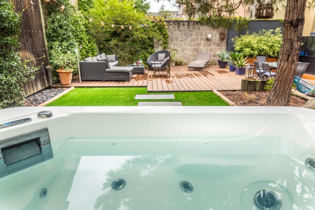 eine Whirlpool-Badewanne im Hinterhof eines Hauses in der Unterkunft SELVES 8 - Maison Jacuzzi in Brive-la-Gaillarde
