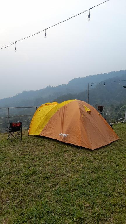a tent sitting on top of a grass field at Paseban Mountain View Camping Ground in Pondok Cipaseban