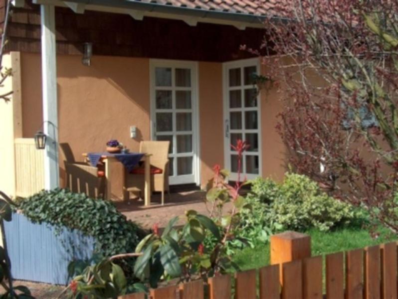 a house with a table and a chair in the yard at Ferienwohnung Am Odenwaldlimes in Vielbrunn