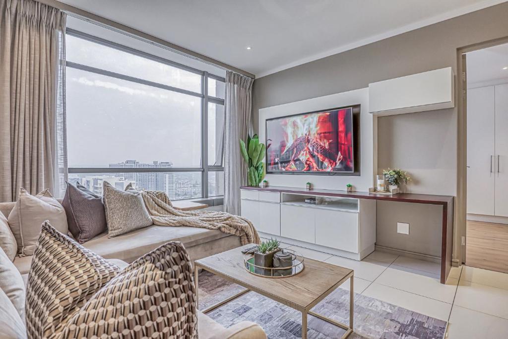 a living room with a couch and a large window at Masingita Towers Premium Hotel in Johannesburg