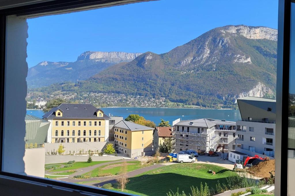 a view from a window of a city and mountains at Le Tableau du Lac 507 - 2 bedrooms apartment with lake view terrace in Annecy