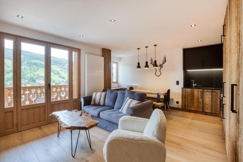 a living room with a blue couch and a table at Warm apartment nestled in the heart of Megeve in Megève