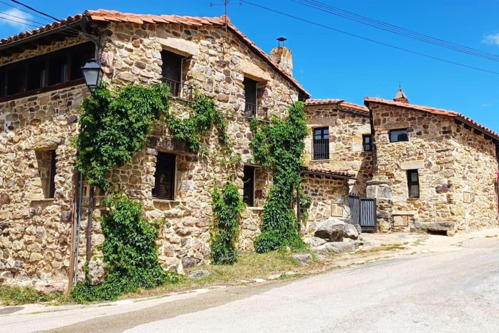 un viejo edificio de piedra con hiedra creciendo en él en Casa Rural con encanto en plena Reserva de Urbión., en Vinuesa