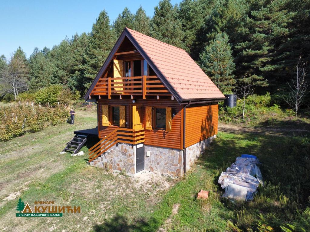 una cabaña de madera en medio de un campo en Brvnare Kušići, en Ivanjica