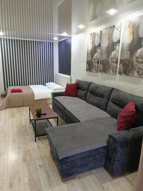 a living room with a couch and a table at Квартира с гостиничным сервисом в центре Петропавловска in Petropavlovsk