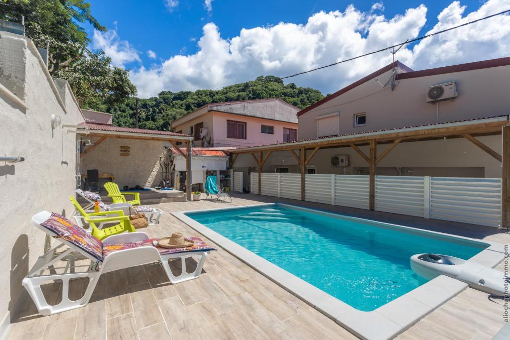 eine Villa mit einem Pool und einem Haus in der Unterkunft Heliconia - Appt avec piscine partagée in Saint-Pierre