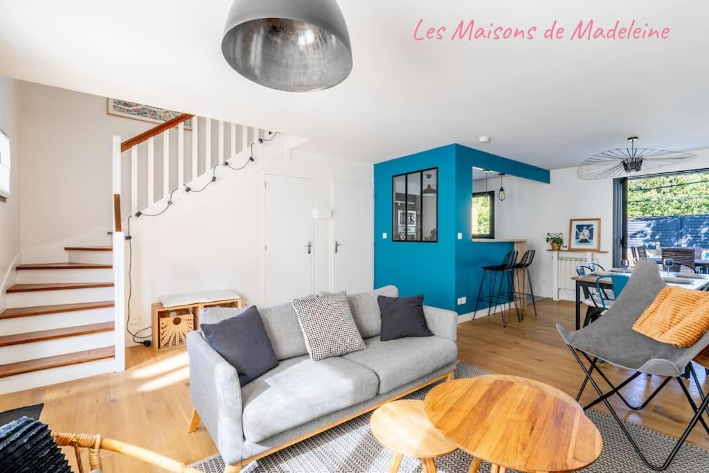 ein Wohnzimmer mit einem Sofa und einem Tisch in der Unterkunft Le coin des Songes - Maison avec jardin in Nantes